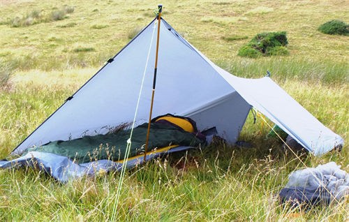 Ultralight trekking pole tent pitched in grassland for lightweight backpacking