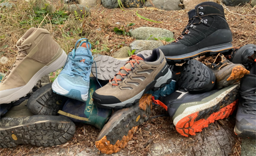 Variety of hiking boots and trail running shoes, comparing footwear options for mountain loop fastpacking trips