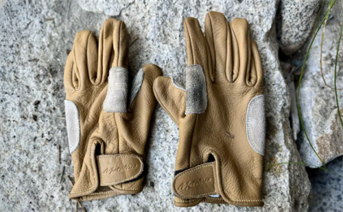 Pair of full-fingered leather climbing gloves with reinforced palm patches, designed for grip and abrasion resistance during alpine ascents