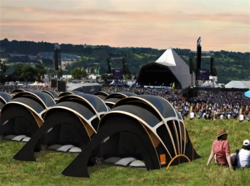 Row of solar fabric tents at a music festival campsite, representing eco-friendly, self-sufficient shelter for outdoor events