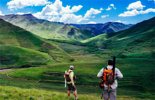 Trekkers admiring the rolling green highland valleys while hiking in Lesotho’s Maloti Mountains