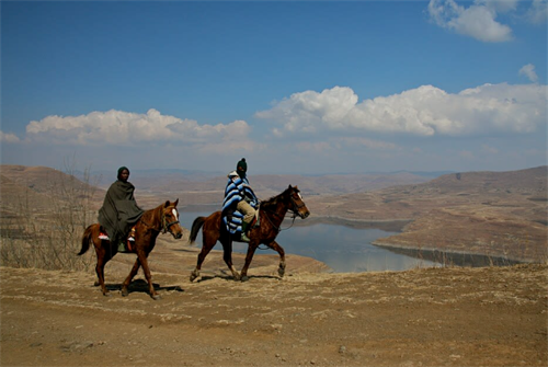 Basotho herders on horseback riding through Lesotho’s highland landscape in the Kingdom of the Sky