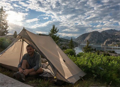 Ultralight tent pitched by a mountain lake, representing the low-weight, high-performance shelter options made possible by graphene and super-polymers