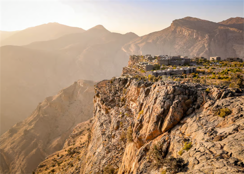 Sunrise view of a mountain village perched on the edge of a canyon in Oman’s Hajar Mountains